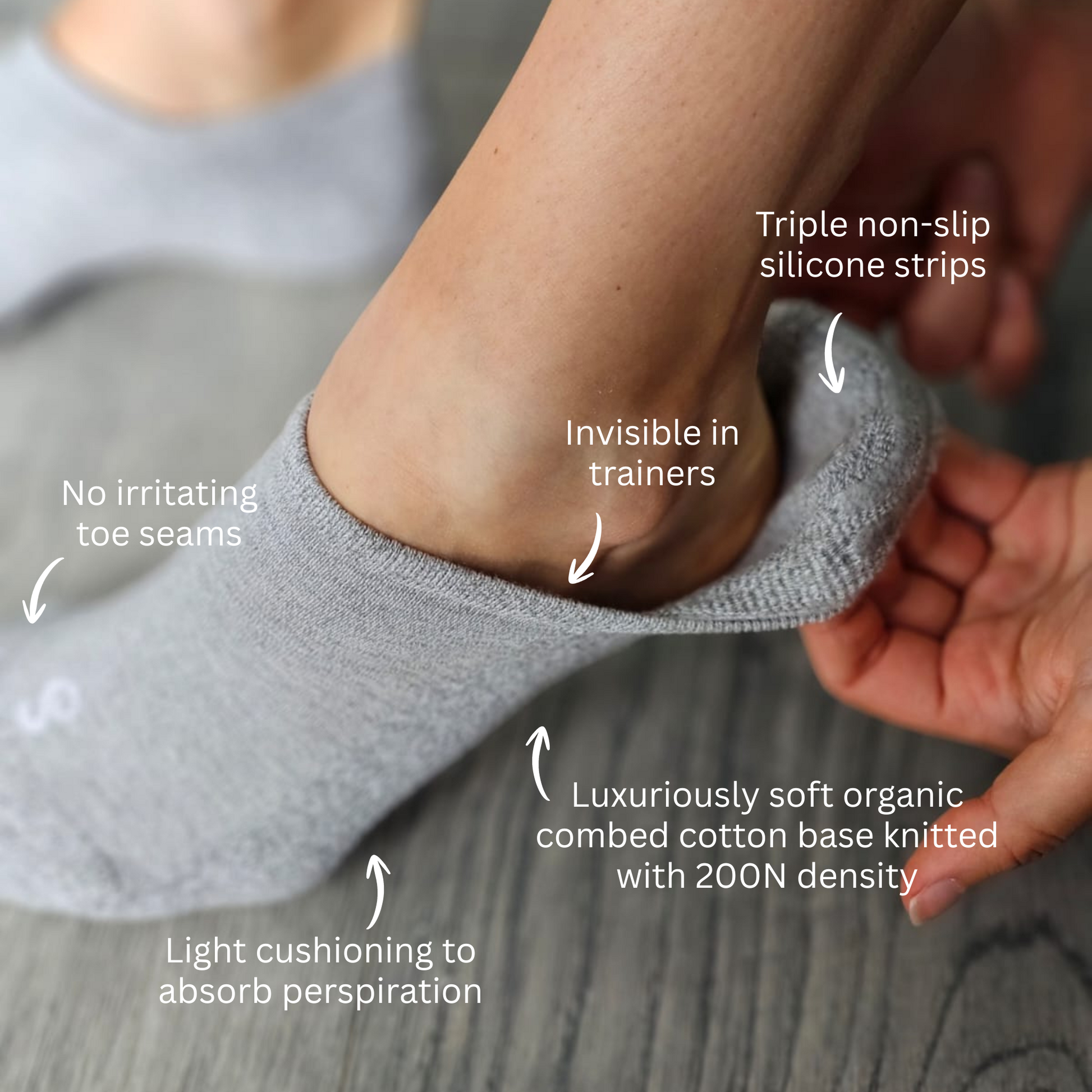 Gray no-show sock being worn with text highlighting features on a neutral background