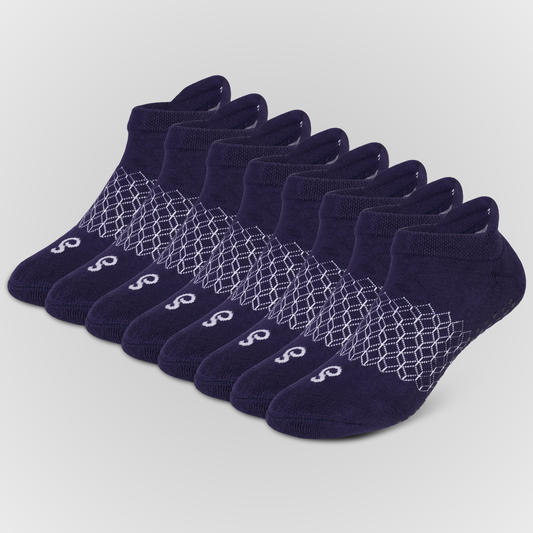 Eight pairs of navy blue hipSwan Flow Ankle low-cut grip socks with a white geometric honeycomb pattern and a small white logo on the toe, arranged in a fan shape on a light gray background.