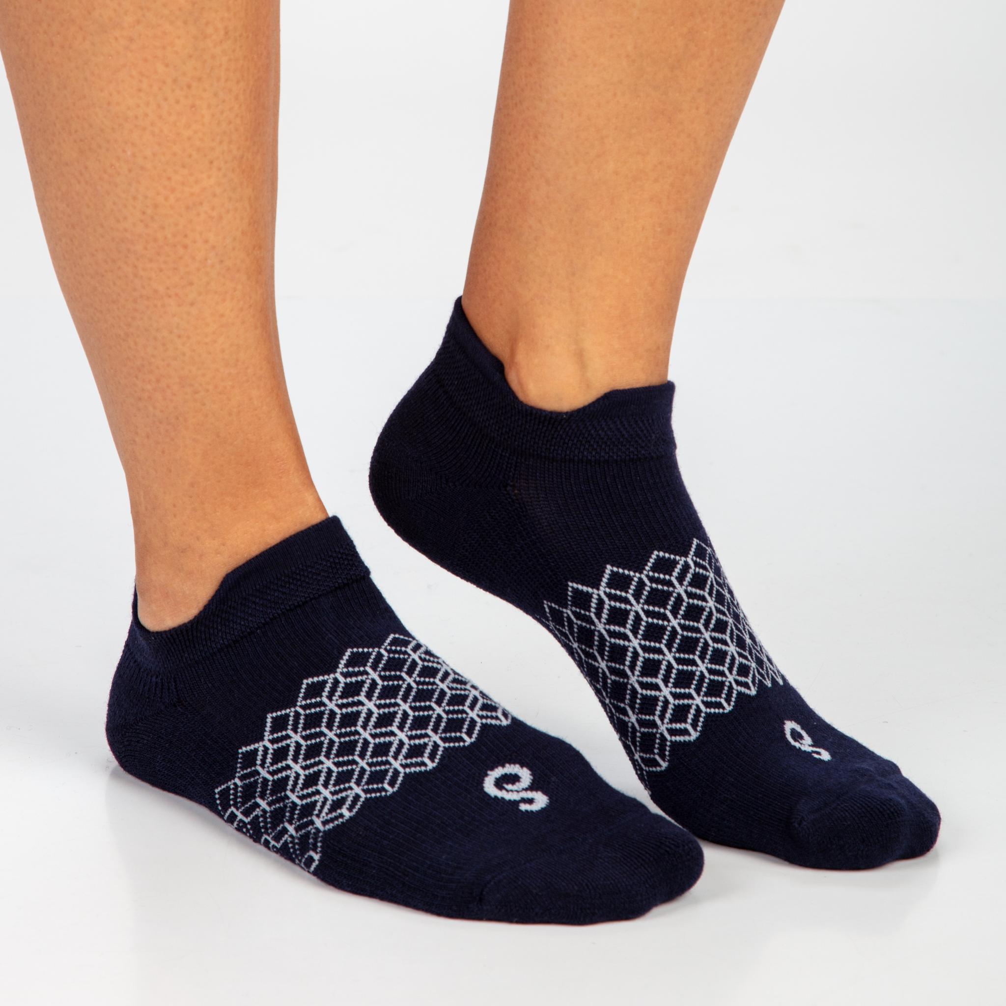 Navy ankle socks with geometric pattern worn by a person on a light gray background